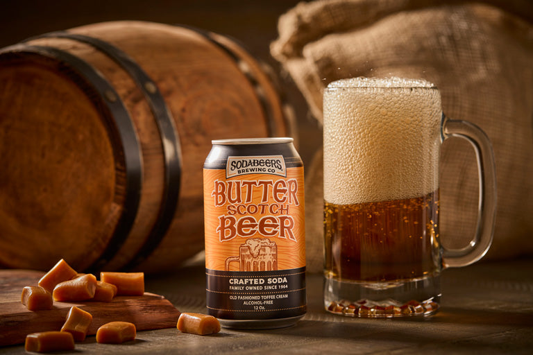 Buttescotch Beer can and glass with caramels on a wooden background