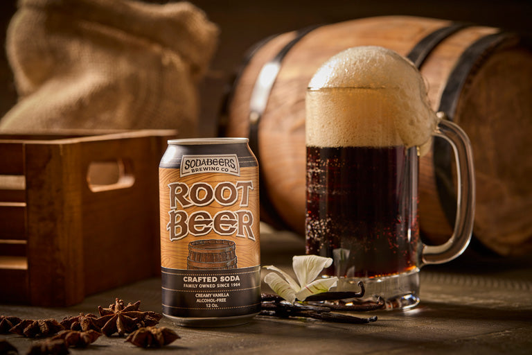 SodaBeers Root Beer can and glass with foam next to wooden barrels